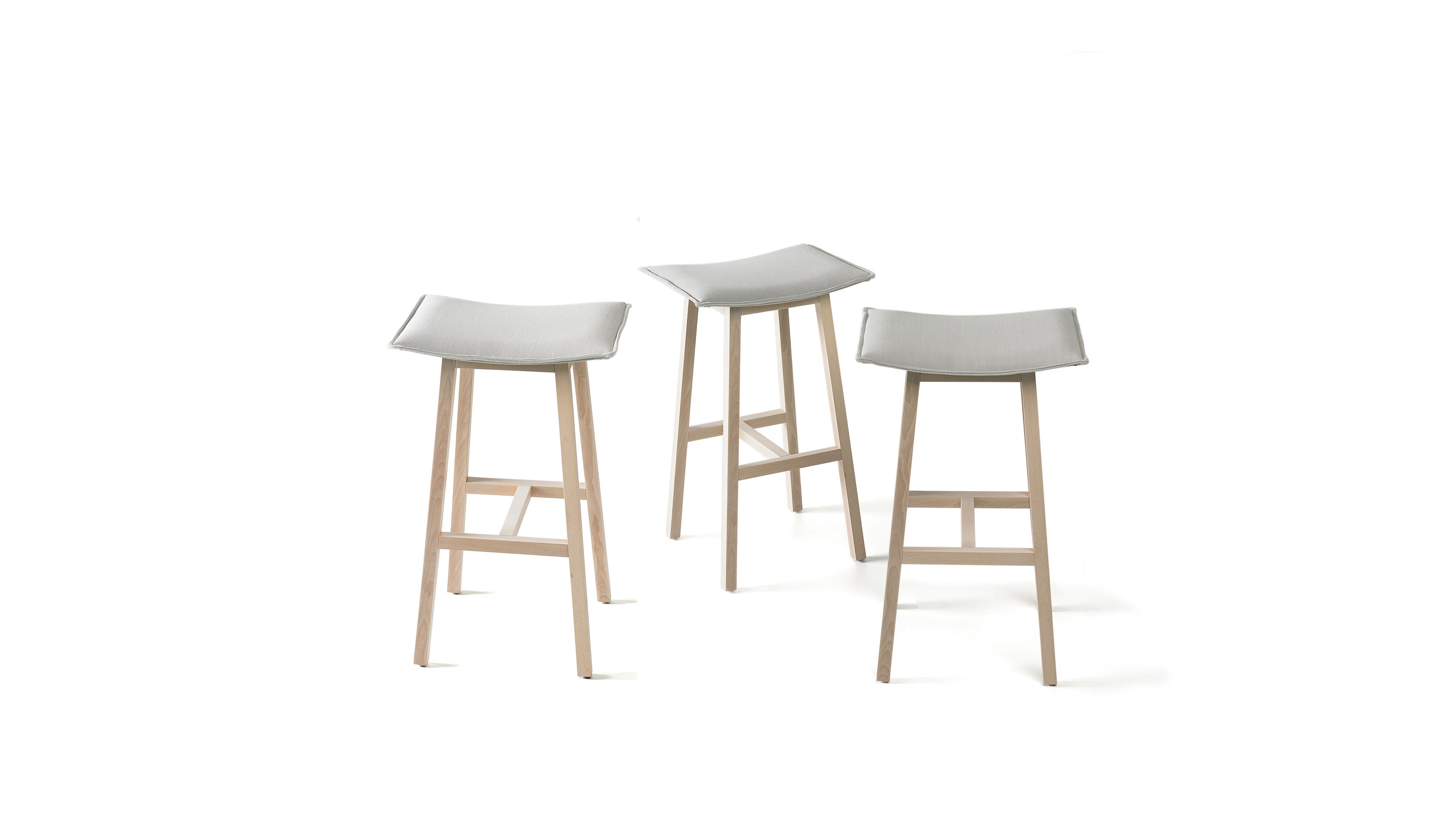 Three bar stools with light gray seats and wooden legs on a white background