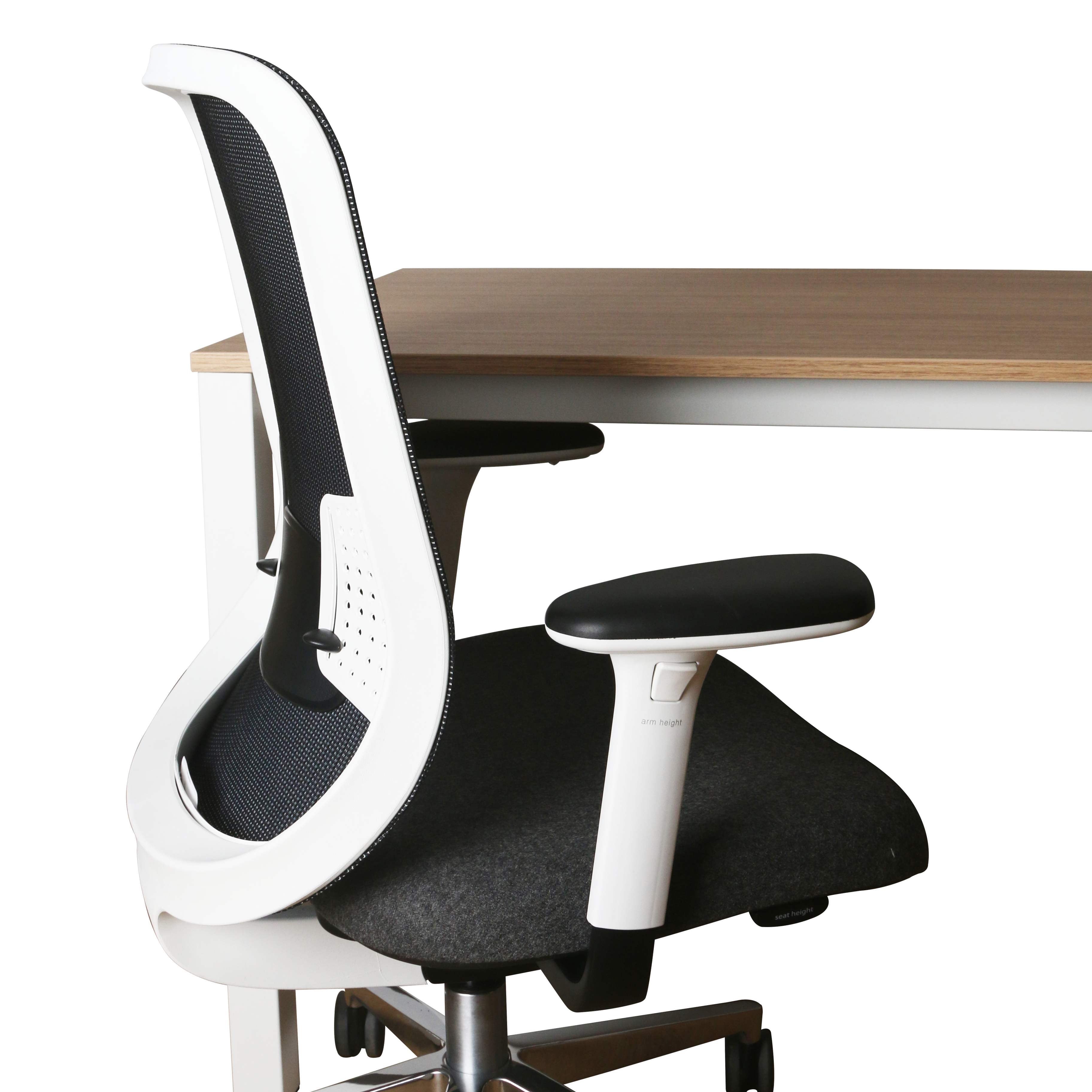 Ergonomic office chair with white frame and black seat and backrest next to a wooden desk on a white background.